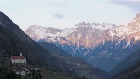 Bergdorf-Im-Tal-Mit-Schneebedeckten-Bergen-In-Der-Abenddämmerung,-Ruhige-Landschaft