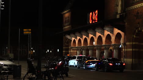 Copenhagen,-Denmark-at-Night,-Lights-on-Central-Train-Station-and-Taxi-Cars-in-Front-of-Building