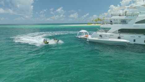 With-each-loop-around-the-yacht,-the-jet-skis-left-behind-a-trail-of-frothy-waves,-adding-excitement-to-the-serene-seascape