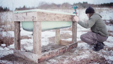 A-Man-is-Employing-a-Level-to-Ensure-the-Alignment-of-the-Homemade-Hot-Tub---Static-Shot