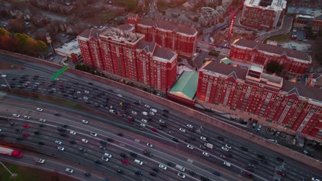 "Aerial-view-of-sunset-over-highway-adjacent-to-vibrant-red-residential-buildings-in-Atlanta,-Georgia