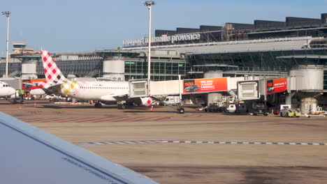 Marseille-Providence-Airport-terminal,-tarmac-from-window-of-plane-at-gate