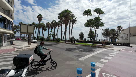 Street-intersection-in-Malaga-Spain,-person-on-bike-try-to-cross-the-street