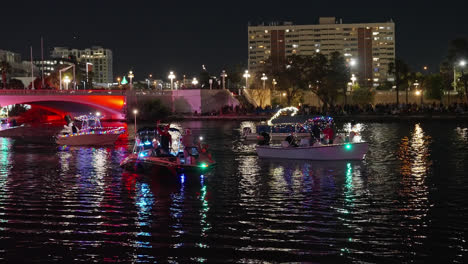 People-Participating-in-a-Christmas-Boat-Parade-on-the-Water-Celebrating-and-Waving-to-a-Crowd-in-Tampa,-Florida