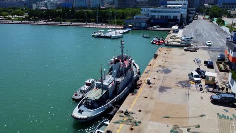 Vuelo-Aéreo-Sobre-Barcos-Atracados-Con-Un-Hermoso-Parque-Al-Fondo-En-Weihai---China