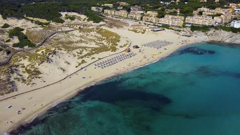 Strand-Cala-Mesquida-Auf-Mallorca,-Spanien-Mit-Türkisfarbenem-Wasser-Und-Sonnenanbetern,-Luftaufnahme