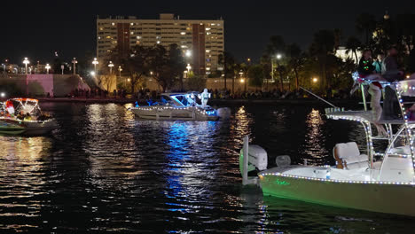 Gente-Celebrando-Las-Fiestas-En-Barcos-Cubiertos-De-Luces-Brillantes-Y-Coloridas-En-Un-Desfile-De-Barcos-Navideños,-Toma-Estática