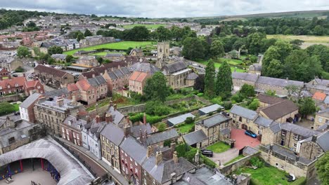 Drone-Shot-of-Alnwick-England-UK,-Old-Medieval-Town-Buildings-Church,-Pottergate-Tower-Landmark
