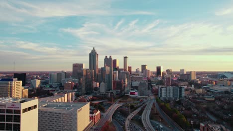 Vista-Aérea-Del-Horizonte-De-Atlanta-Al-Atardecer-Con-Rascacielos-Urbanos-Y-Carreteras-Transitadas