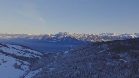Drohnenansicht-Des-Morgenhimmels,-Der-Eine-Silhouette-über-Schneebedeckte-Berge-Wirft