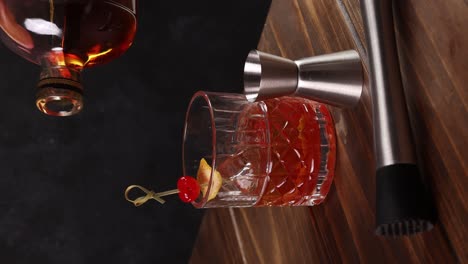 Altmodischer-Cocktail,-Chilenische-Version-Mit-Bourbon-Whiskey,-Zucker,-Eis,-Bitteren-Tropfen,-Maraschinokirsche-Auf-Dunklem-Hintergrund-Und-Vertikalem-Video-Mit-Selektivem-Fokus