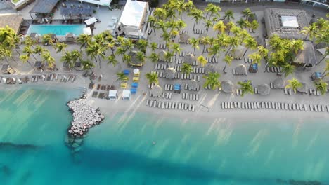 Sonnenliegen-Am-Strand-Von-Resort-Am-Mambo-Beach-Auf-Curaçao,-Luftaufnahme