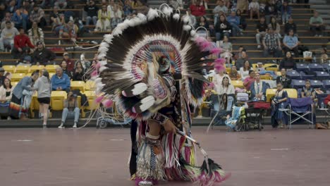 Captura-En-Cámara-Lenta-A-Increíbles-Bailarines-Nativos-Americanos-Compitiendo-En-El-Escaparate-Tradicional-Masculino-En-Un-Powwow-Bajo-Techo