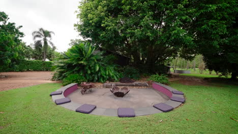 Rural-Prestigious-Tropical-Style-Home-Firepit-Area-In-Circular-Dropped-Bench-With-Seat-Cushions,-Pullback