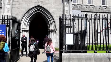 Tilt-up-shot-on-St-Patrick's-Cathedral-entrance-as-tourists-visit-in-daytime,-Dublin