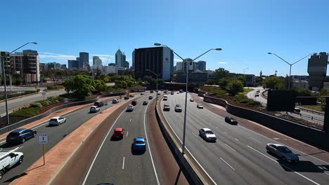 Freeway-traffic-flowing-and-Transperth-train-arriving-at-Claisebrook-station-in-the-background