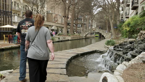 Couple-Walks-Along-San-Antonio,-Texas,-River-Walk