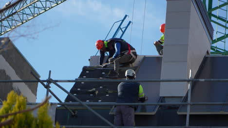 Workers-preparing-the-roof-for-mounting-solar-panels-on-house-roof