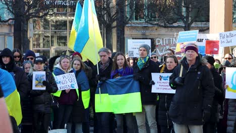 People-with-Ukrainian-flags-and-signs-protest-Russian-war,-Stockholm