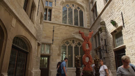 Visitors-Observing-the-De-Gulle-Waard-Statue-at-Het-Steen-in-Antwerp,-Belgium---Pan-Up-Shot