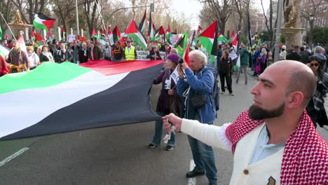 Demonstranten-Halten-Während-Eines-Solidaritätsmarsches-Mit-Palästina-Eine-Große-Palästinensische-Flagge