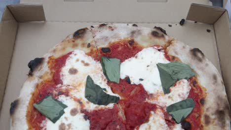 Cooked-Margherita-pizza-in-a-take-out-box-from-Pizzeria-Bianco-in-Phoenix,-Arizona-with-video-tilting-down