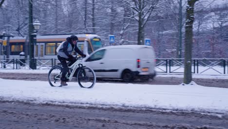 Ciclista-En-Bicicleta-En-La-Acera-Nevada-Durante-El-Invierno-En-Bruselas,-Bélgica