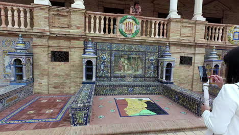 Young-woman-taking-pictures-of-Plaza-de-España-with-smartphone,-back-motion-view