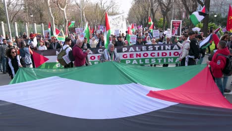 Los-Manifestantes-Sostienen-Una-Gran-Bandera-Palestina-Durante-Una-Marcha-En-Solidaridad-Con-Palestina.