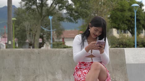 Clip-Cinematográfico-De-Una-Joven-Latina-Morena-Usando-Su-Teléfono-Y-Riendo