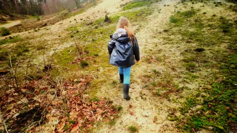 Girl-walks-through-dunes-in-Dutch-national-park-Maasduinen-rear-view-slowmotion