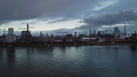 Drone-Shot,-Chemical-Factory-Buildings-in-Riverside-Industrial-Area-at-Twilight