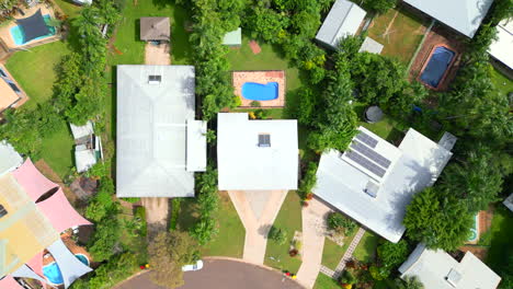 Aerial-drone-of-large-Residential-Tropical-Block-with-Huge-House-and-Pool-on-curved-street,-triangular-driveway,-Top-Down-bird's-eye-view-rotate-descend