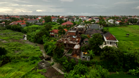 Villas-En-La-Campiña-De-Bali-Rodeadas-De-Exuberantes-Campos-De-Arroz,-Arco-Aéreo