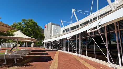 Walking-alongside-curved-glass-exterior-of-modern-architecture-design-college-campus-building