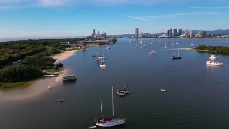 Aerial-views-moving-South-towards-Surfers-Paradise,-over-yachts-on-anchor-and-the-Broadwater-on-the-Gold-Coast,-Australia