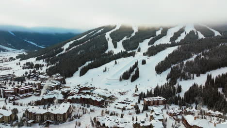 Copper-Mountain-foggy-cloud-layer-winter-snowy-early-morning-sunrise-aerial-drone-Colorado-ski-resort-i70-Eagle-Flyer-lift-center-village-half-pipe-Ikon-Epic-pass-snowboarding-backward-slowly-reveal