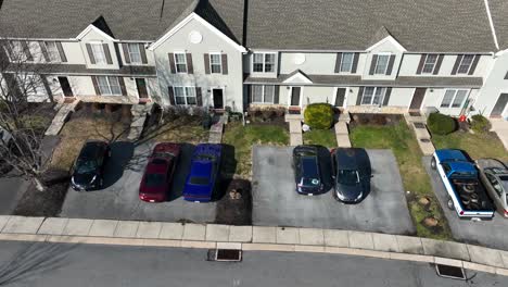 Aerial-landing-shot-of-parking-cars-in-front-of-american-community