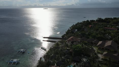 Tropical-coastline-of-Cebu-Island-with-shimmering-sea-at-sunset,-aerial-view