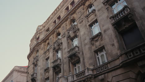 Fassade-Eines-Gebäudes-In-Budapest,-Ungarn,-Schöne-Architektur,-Altes-Wohnhaus-In-Der-Stadt,-Außenansicht-Eines-Alten-Renovierten-Mehrstöckigen-Wohnhauses,-Große-Fenster,-Balkon,-Urbanes-Europa