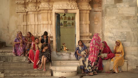 At-a-prayer-temple-near-Pichola-Lake-in-Udaipur,-Rajasthan,-a-group-of-women-wearing-colorful-saris-has-gathered