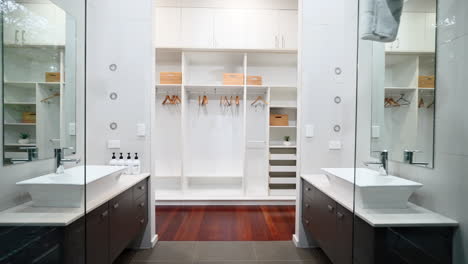 Dolly-push-in-past-clear-glass-panel-ensuite-bathroom-to-open-walk-in-robe-closet-with-wicker-baskets