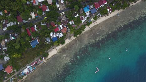 Oslob-coastal-town-with-clear-turquoise-waters-and-boats,-philippines,-sunny-day,-aerial-view