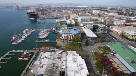 Oakland-CA-USA,-Aerial-View-of-Waterfront-Buildings,-Boats-in-Marina-and-Inner-Harbor-Bay,-Revealing-Drone-Shot