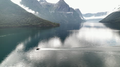 Aerial-Panoramic-View-of-Motorboat-Navigating-Fast-On-Eikesdalsvatnet-Lake-In-Norway