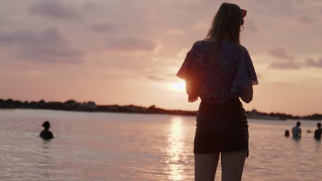Nicht-Erkennbares-Mädchen-Steht-Bei-Sonnenuntergang-In-Der-Karibik-Neben-Menschen-Im-Wasser