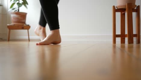 Women-feet-dancing-barefoot-on-wooden-floor-in-apartment