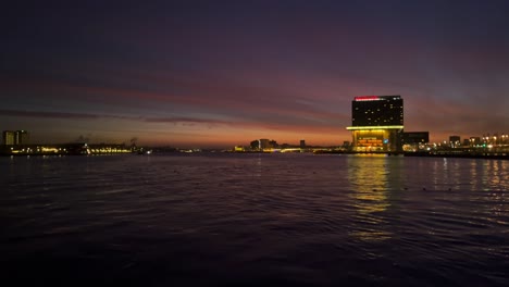 Twilight-night-exterior-of-Movenpick-hotel-next-to-IJ-river-in-Amsterdam-Netherlands