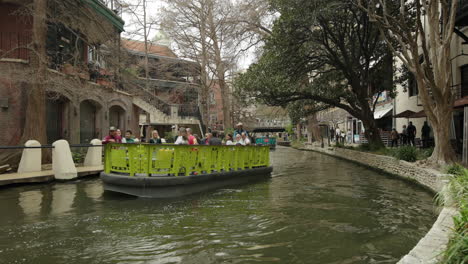 Boat-Full-of-Tourists-Floats-Down-San-Antonio's-River-Walk-in-Texas,-USA