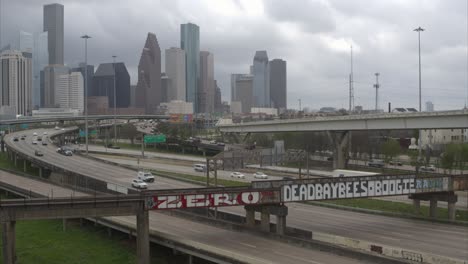 Toma-Descendente-De-Un-Dron-Del-Paisaje-Urbano-Del-Centro-De-Houston-Que-Revela-Un-Gran-Caimán-En-El-Pantano-De-Buffalo